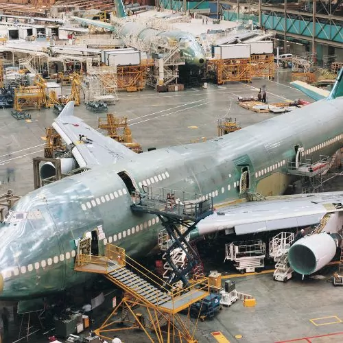 Línea de montaje de aviones comerciales con fuselajes de aluminio y plataformas de trabajo